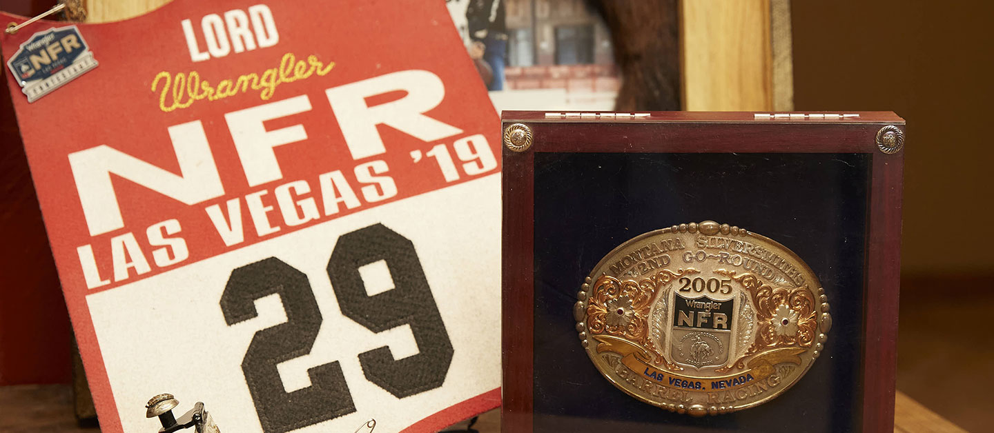 A National Finals Rodeo back number posed next to her world qualifying belt buckle and spurs for winning a round at the NFR. 